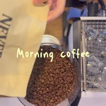 Fresh coffee beans pouring from a Never A Day's Trouble bag into the grinder, captioned “Morning coffee”